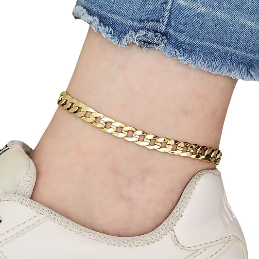 Gold concave Cuban chain anklet on a person's ankle with denim shorts and white sneakers.