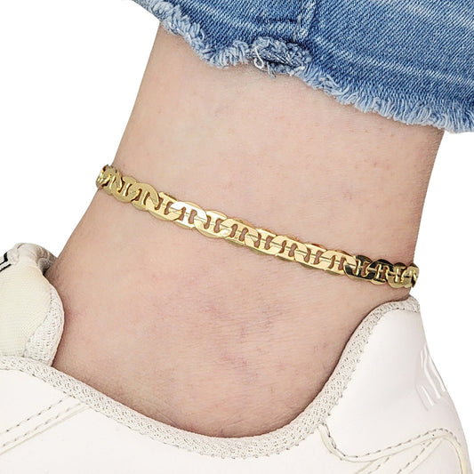 Gold mariner anklet on a person's ankle with denim shorts and white shoes.