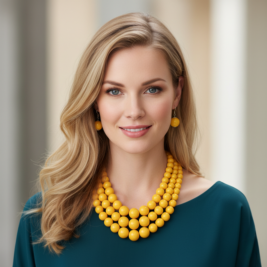 Woman wearing a yellow necklace and earrings against a neutral background