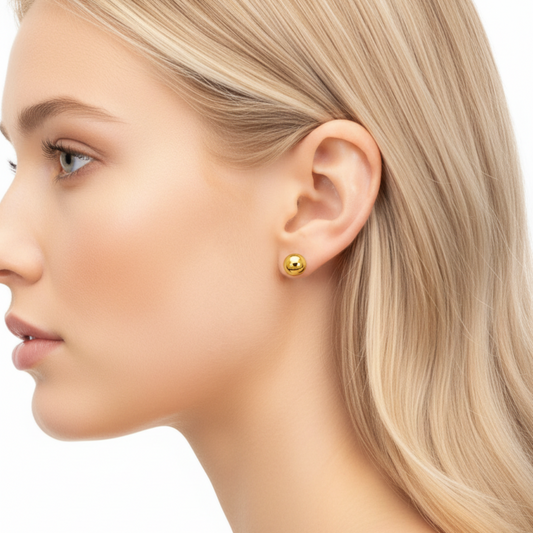 Close-up of a woman wearing gold earrings on a white background