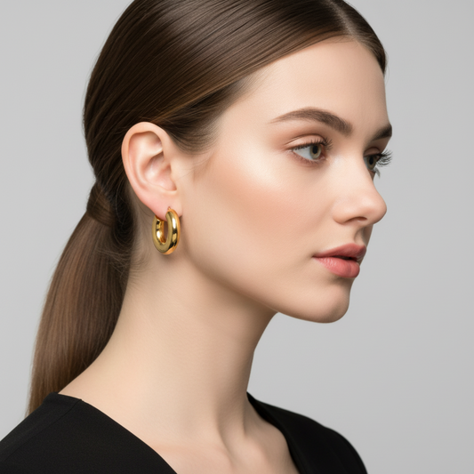 Woman wearing gold hoop earrings against a neutral background