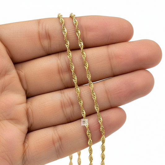 Gold Twist chain held between fingers on a white background