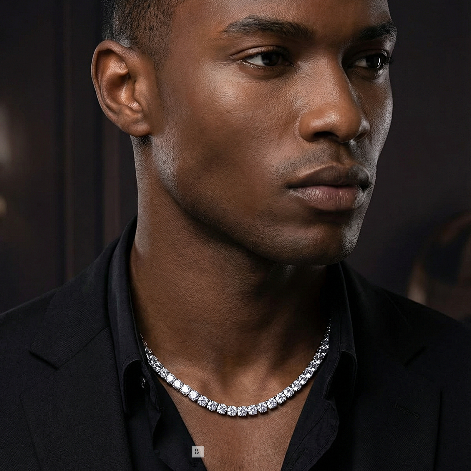 Man wearing a diamond necklace against a dark background