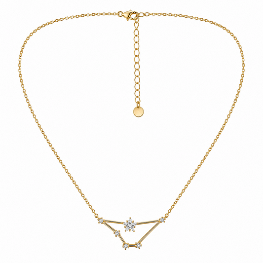 A gold chain necklace with a geometric pendant featuring a central clear gemstone and small clear stones, displayed on a clean white background.