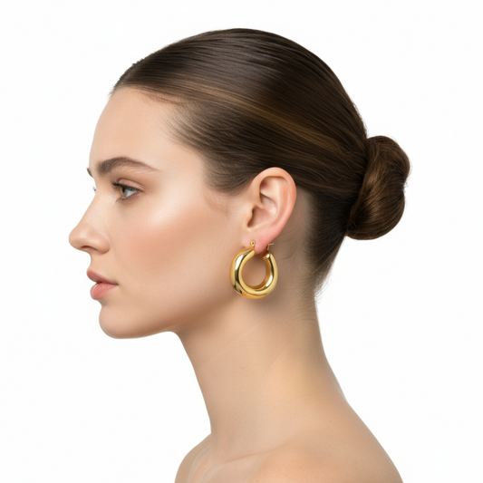 Woman wearing gold hoop earrings on a white background