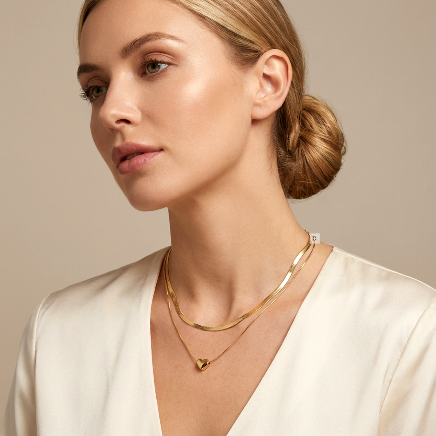 Woman wearing a gold necklace with a beige background