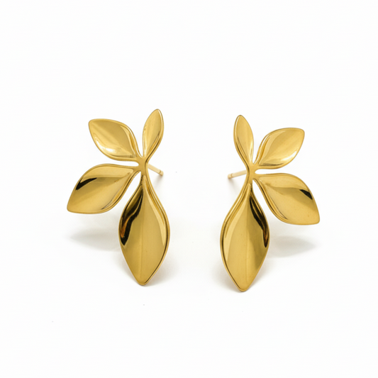 Pair of gold leaf-shaped earrings on a white background