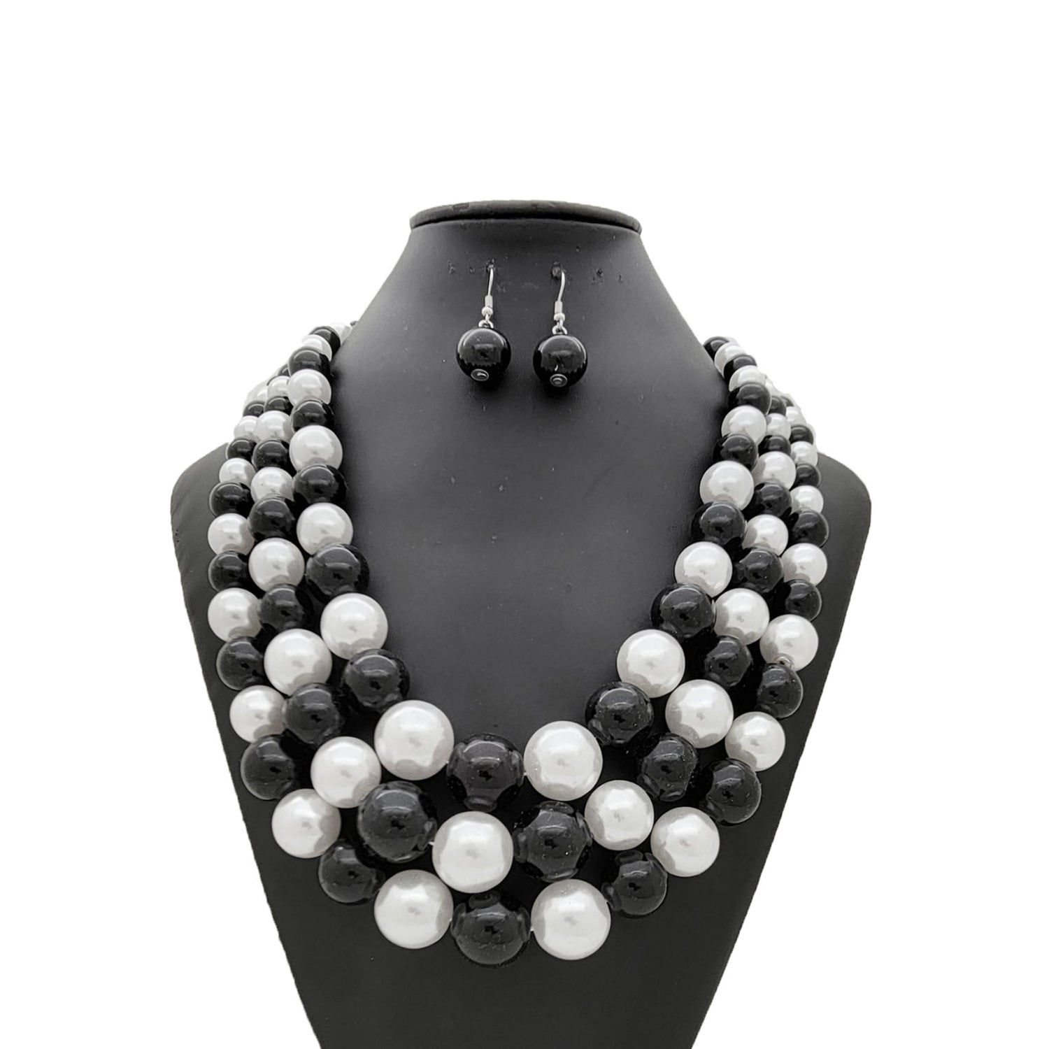 Black and white pearl necklace and earrings set on a black mannequin bust.