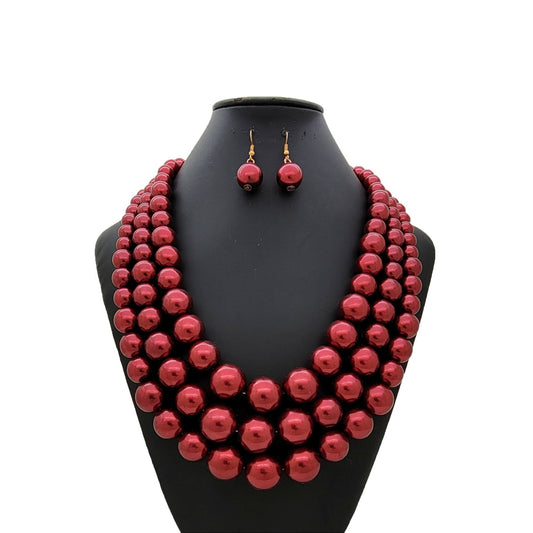 Burgundy beaded necklace and earrings on a black mannequin bust against a white background