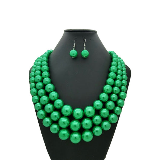 Green beaded necklace and earrings on a black mannequin bust against a white background