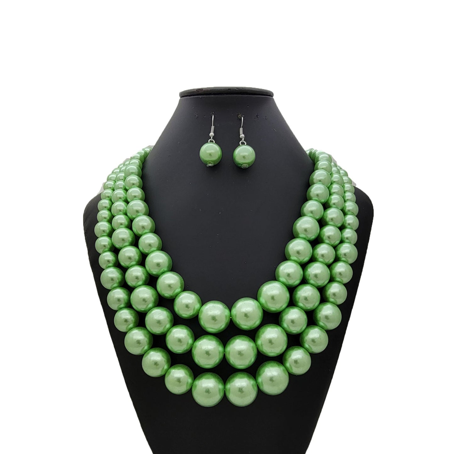 Green pearl necklace and earrings set on a black mannequin bust against a white background