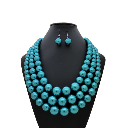 Teal beaded necklace and earrings on a black mannequin bust against a white background