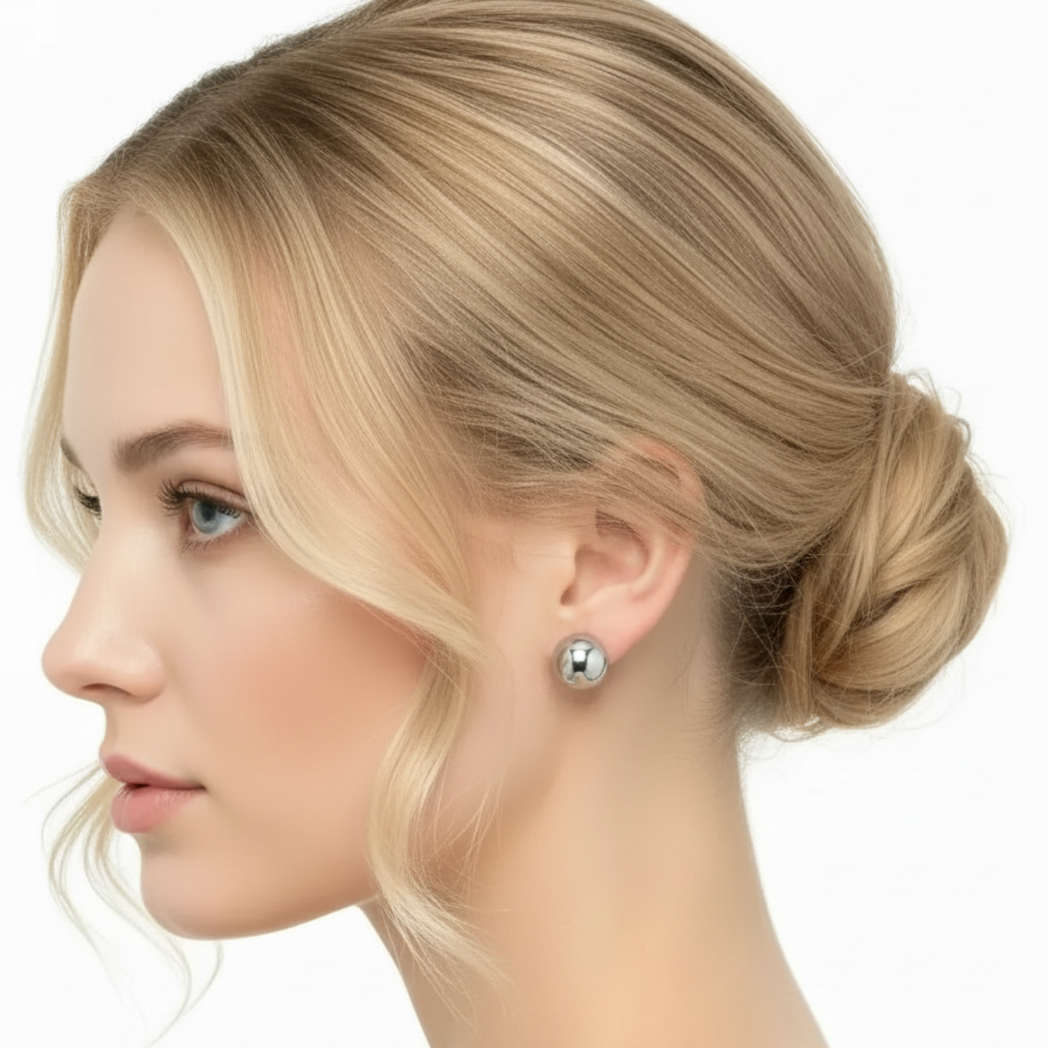 Woman with styled blonde hair and pearl earrings on a white background