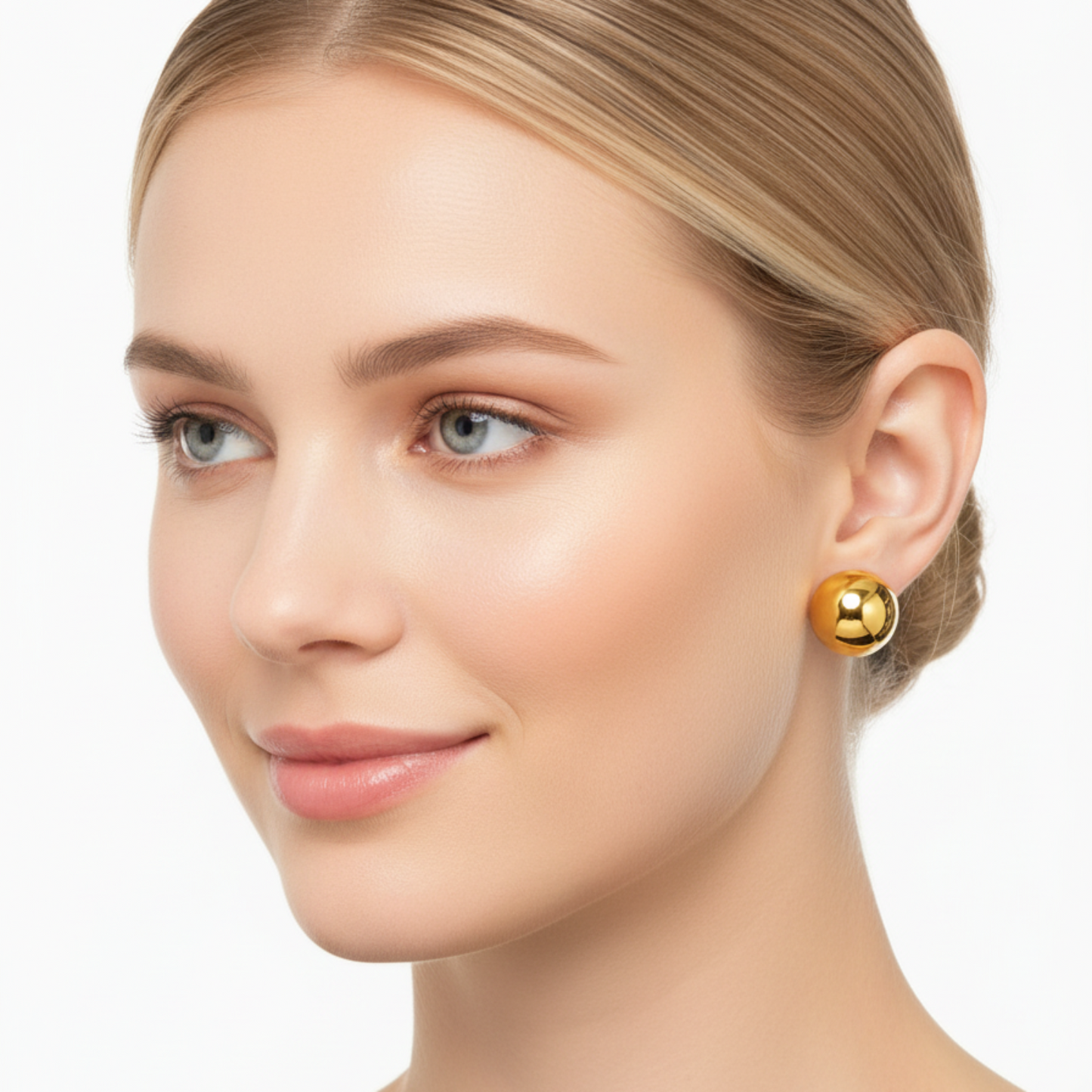 Woman wearing gold earrings on a white background