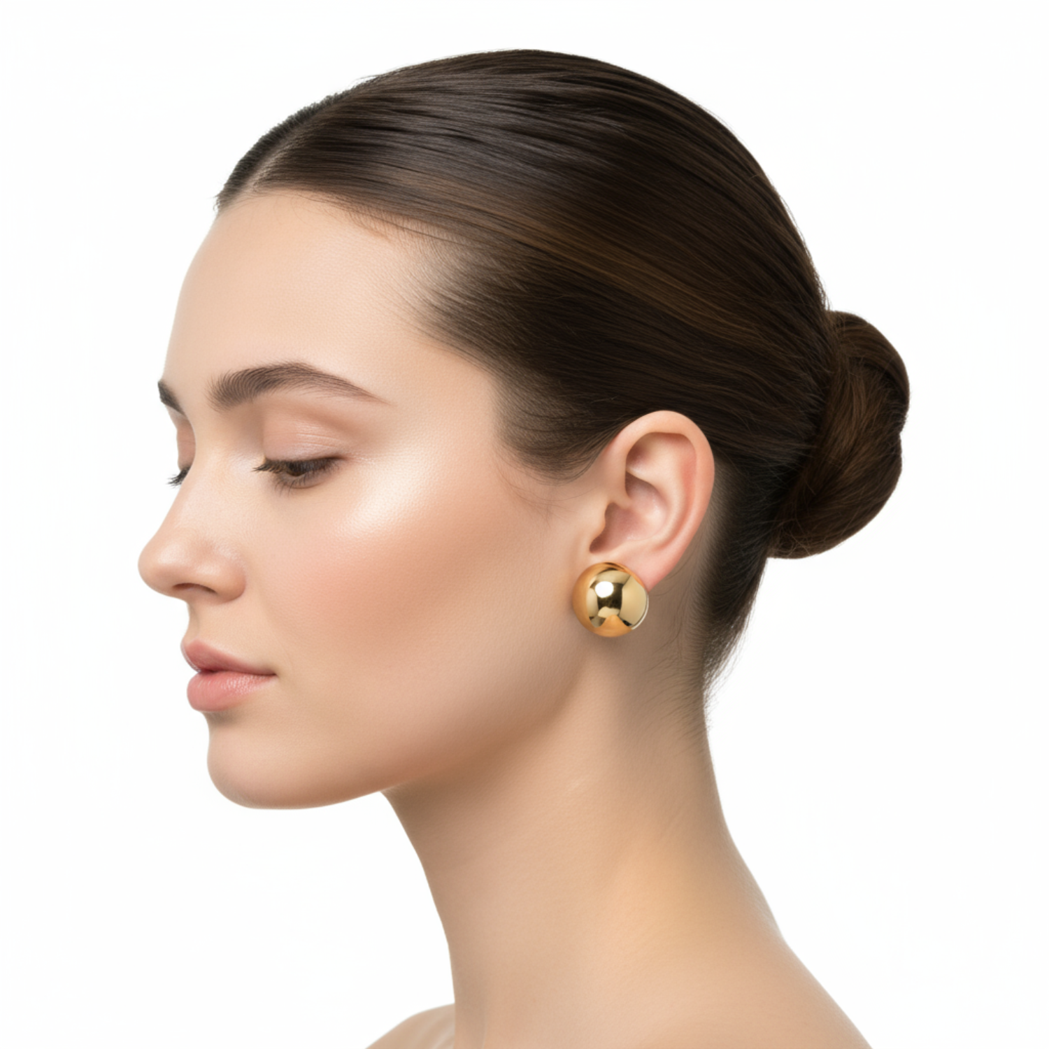 Woman wearing gold earrings on a white background