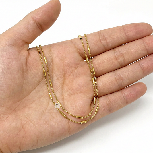 Gold chain necklace on a hand with a white background