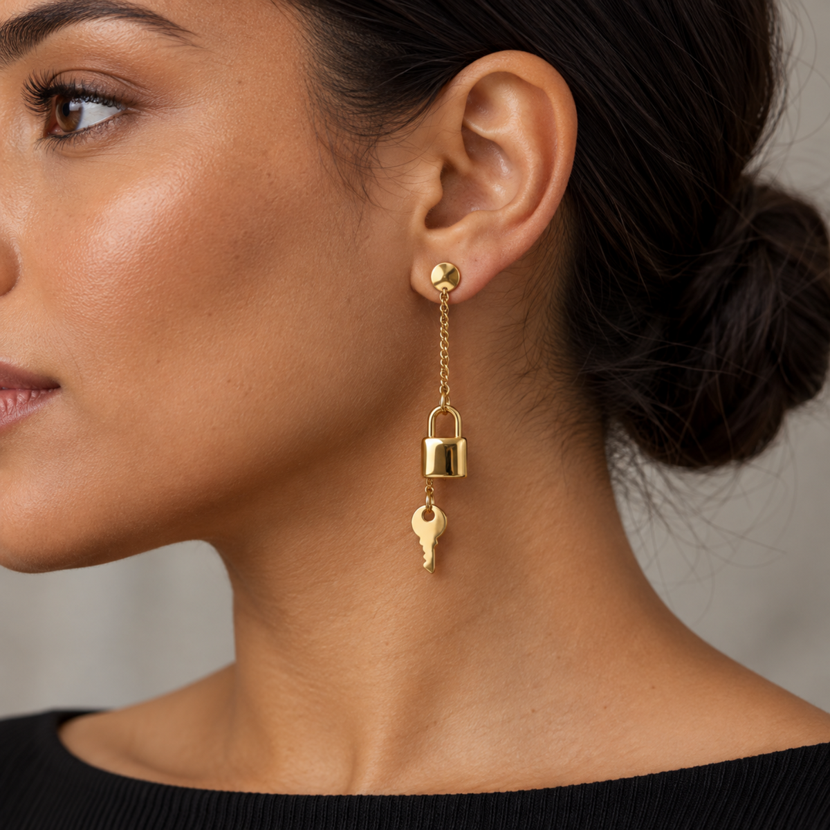 Women wearing gold tone stainless steel lock and key dangling earring