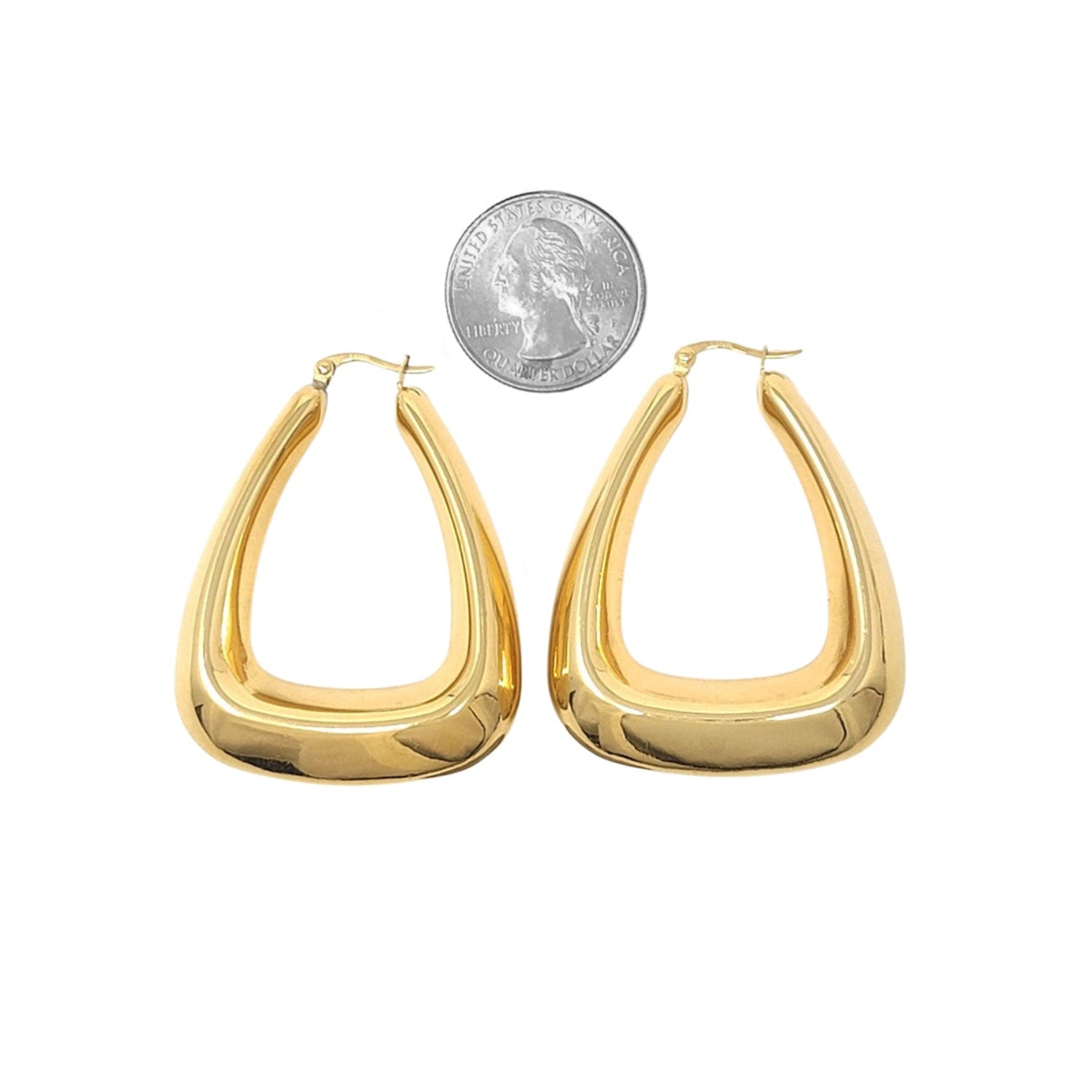 Gold hoop earrings with a quarter for scale on a white background