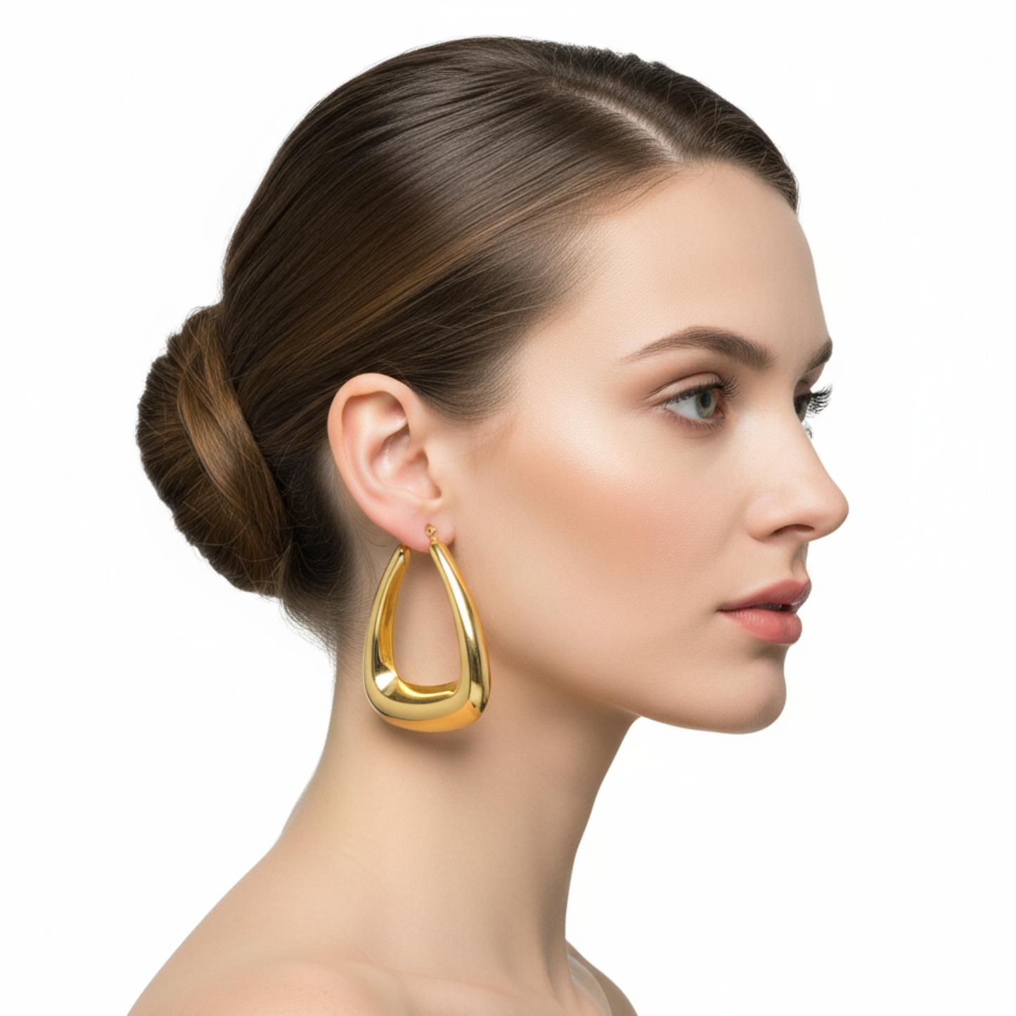 Woman wearing gold hoop earrings on a white background